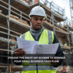 Black British construction site manager reviewing invoices at a building site, representing VAT schemes for small businesses.